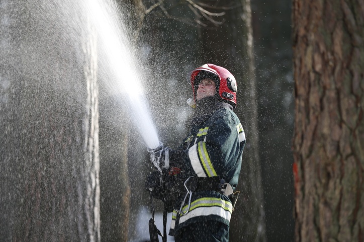 Bombero con espuma apagando fuego